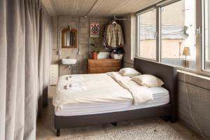 a small bedroom with a bed and a window at Mari's: Multifunctional Shelter with big Garden in Ghent +17 photos