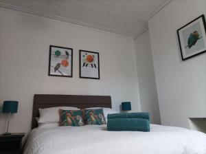 a bedroom with a white bed with pictures on the wall at Victorian Renovation Room 4 in Liverpool