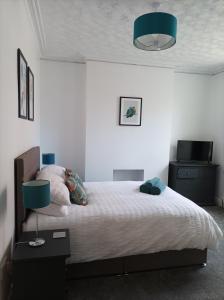 a bedroom with a large bed with a blue lamp at Victorian Renovation Room 4 in Liverpool