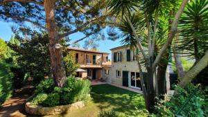 una casa con un cortile alberato di fronte di Villa Vuyani Antibes a Antibes