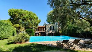 a swimming pool with chairs and a house at Villa Vuyani Antibes in Antibes