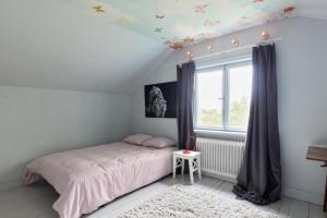 Schlafzimmer mit einem Bett und einem Fenster mit Schmetterlingen an der Decke in der Unterkunft Fantastic 4 bedroom home in Bromma with everything in Stockholm