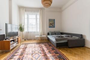 a living room with a bed and a flat screen tv at Klauzal apartment w/3 bedrooms, french balcony in Budapest