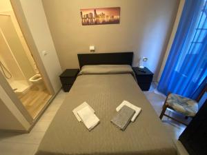 a bedroom with a large bed with two towels on it at Hotel La Pergola in Loano