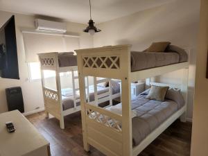 two bunk beds in a room with a table at Brisa del Sur in Puerto Madryn