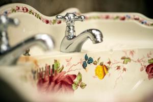 a bathroom sink with flowers painted on it at AltoCanto in Coimbra