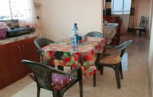 a table with chairs and a bottle of water on it at Adorable 2bedroom homestay in Beau Bassin