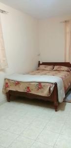 a bed in a room with a bedspread with flowers on it at Adorable 2bedroom homestay in Beau Bassin