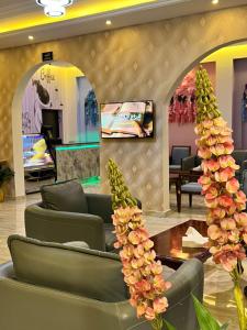 un vestíbulo con sillas y una mesa con plantas de piña en Wahaj Al Mesak Units, en Dammam