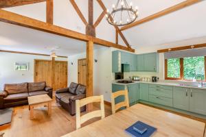 Ploony Hill Lodge في Bleddfa: مطبخ وغرفة معيشة مع أريكة وطاولة