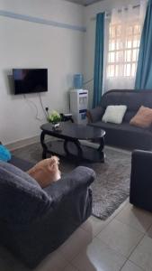 um cão deitado num sofá numa sala de estar em Golden One-bedroom serviced apartment with free WiFi em Kisii
