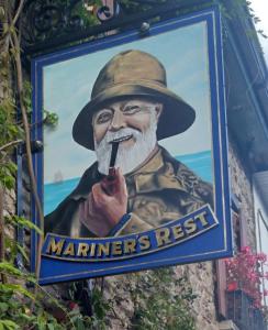Un segno con la foto di un uomo con un tubo di Up Stairs Double Apartment Innishannon Mariners Rest a Cork