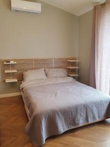 1 dormitorio con 1 cama grande y cabecero de madera en Apartament Imara-klimatyzacja, miejsce parkingowe, en Łódź