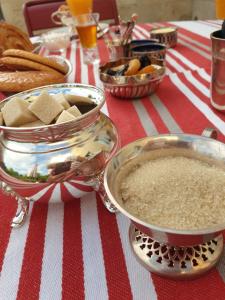 una mesa con un mantel de rayas rojas y blancas con comida en La Maison des Thermes, Chambre d'hôte en Saintes