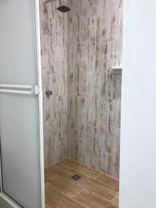 y baño con ducha y suelo de madera. en Casa 39-37, en Cartagena de Indias