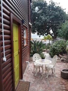 d'une terrasse avec une table et des chaises à côté d'une porte. dans l'établissement Coastal Cottage, à Klein-Brakrivier