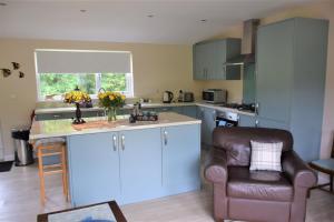 a kitchen with blue cabinets and a chair and a counter at Ridge View Lodge in Dumfries