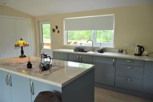 eine Küche mit einer Theke, einem Waschbecken und einem Fenster in der Unterkunft Ridge View Lodge in Dumfries