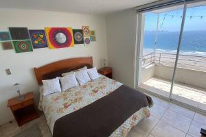 a bedroom with a bed with a view of the ocean at Departamento encantador en una ciudad maravillosa in Coquimbo