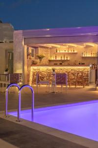 a swimming pool at night with a bar in the background at Sea Wind Villas and Suites in Tourlos