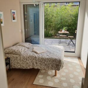 - une chambre avec un lit et une porte coulissante en verre dans l'établissement Jolie suite parentale, chambre et salle d'eau, avec son coin de verdure à 5 minutes à pied du centre ville, à Bordeaux