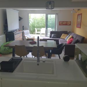 a kitchen and living room with a table and a couch at Jolie suite parentale, chambre et salle d'eau, avec son coin de verdure à 5 minutes à pied du centre ville in Bordeaux