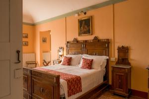 a bedroom with a large bed with a wooden headboard at Albergo Real Castello in Verduno
