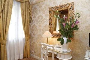 a room with a vase of flowers on a table with a mirror at Casa dei Cavalieri in Venice