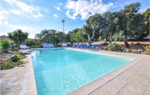 una piscina con sillas azules y árboles en 2 Bedroom Beautiful Home In Sedini, en Sedini