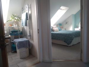 ein Schlafzimmer mit einem Bett und einem Spiegel in einem Zimmer in der Unterkunft Village life- Private suite - Living Room, Bedroom and Bathroom in Newtown Saint Boswells