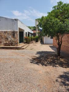 a building with a tree in the middle of a street at Suíte 10 Privativa e Aconchegante in Cuiabá