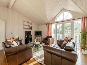 a living room with two leather couches and a window at Beech Tree Lodge in Willington