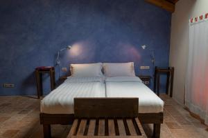 um quarto com uma cama e uma parede azul em Albergo Real Castello em Verduno