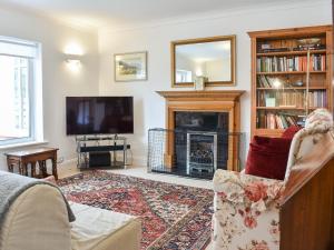 a living room with a fireplace and a television at Farnley Ridge in Durham