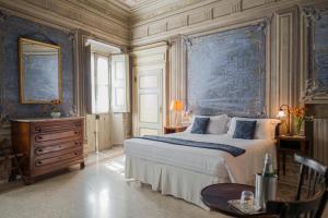 a bedroom with a large bed and blue wallpaper at Albergo Real Castello in Verduno