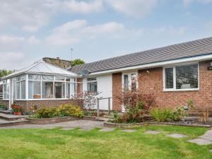 a brick house with a greenhouse in the yard at Farnley Ridge in Durham