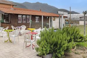 a patio with white chairs and tables and a house at Casa Sanfè in Albenga