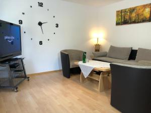 ein Wohnzimmer mit einem Sofa, einem Tisch und einem TV in der Unterkunft Ferienwohnung Familie Hinrichs in Dorn-Dürkheim