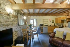 eine Küche und ein Wohnzimmer mit einem Sofa und einem Tisch in der Unterkunft Critchlow Cottage in Buxton