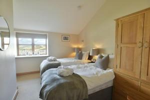 a bedroom with two beds and a window at Sheldon Cottage in Buxton