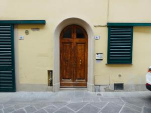eine Holztür an der Seite eines Gebäudes in der Unterkunft Maila Apartments 25min from Florence in Prato