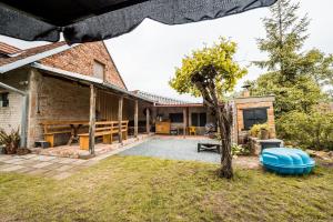 eine Außenterrasse mit einem Baum und einem Haus in der Unterkunft Apartmán ve Dvoře in Ratíškovice