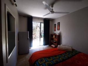 um quarto com uma cama com um cobertor vermelho e uma janela em The Aces - NUDE - SunEden Family Naturist Resort em Pretoria