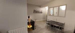 een woonkamer met een tafel en een gitaar bij La Fabrique in Bourg-en-Bresse