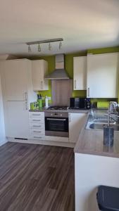 a kitchen with a sink and a stove top oven at Well Furnished 3 Bedroom House in a cosy estate in Bolton in Bolton