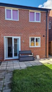 a brick building with a bench in front of it at Well Furnished 3 Bedroom House in a cosy estate in Bolton in Bolton