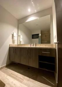 a bathroom with a sink and a large mirror at Syrena 401 y 606 in Playa del Carmen