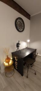 een kantoor met een bureau en een klok aan de muur bij La Fabrique in Bourg-en-Bresse