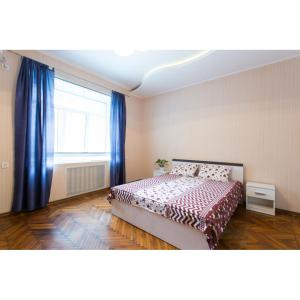 a bedroom with a bed and a window with blue curtains at Pushkinskaya street in Kharkiv