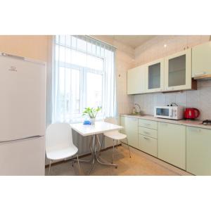 a kitchen with a white table and chairs and a window at Pushkinskaya street in Kharkiv